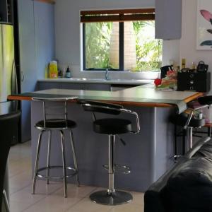 een keuken met 2 barkrukken en een aanrecht bij Sunny Sandringham SkyTower Views Close to City in Auckland
