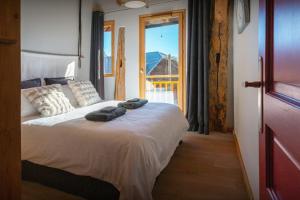 a bedroom with a bed with towels on it at La Ferme des Artistes - OVO Network in Mieussy