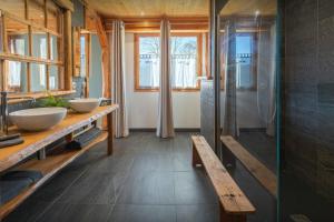 a bathroom with two sinks and a bench in it at La Ferme des Artistes - OVO Network in Mieussy