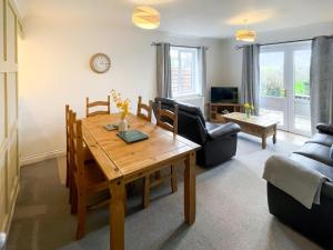 a living room with a wooden table and a couch at Dartmoor View in Stoke Gabriel