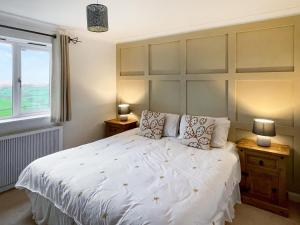 1 dormitorio con 1 cama blanca grande y 2 lámparas en Dartmoor View en Stoke Gabriel