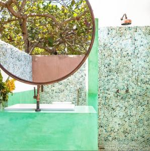 un espejo sentado sobre una mesa junto a una pared en Casa Bora Lá en Caraíva