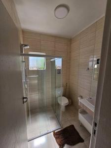 een badkamer met een douche, een toilet en een wastafel bij casa c/piscina enseada guaruja in Guarujá