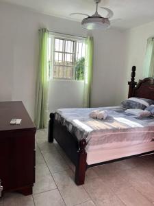 Schlafzimmer mit einem Bett, einem Tisch und einem Fenster in der Unterkunft City suite Sosua AptStudio in Sosúa