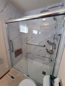 a glass shower in a bathroom with a toilet at The Dewberry Homestay B&B in Edmonton
