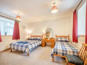 a bedroom with two beds and a mirror at Brondeg Lodge in Crarae