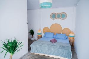 a bedroom with a bed with blue pillows at Woywoy Paradise in Bira