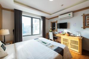 a hotel room with a bed and a desk and a window at Sapa Highland Resort & Spa in Sapa