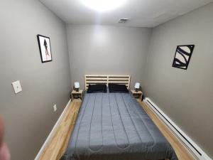 a bed in a room with two night stands at Mins to NYC- 3Bed Superb Fully Furnished in Jersey City
