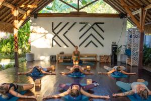 a group of people doing yoga in a room at Kayu Mama Resort and Spa in Uluwatu