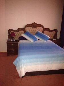 a bedroom with a bed with blue sheets and pillows at Pilot Inn Accommodation in Kempton Park