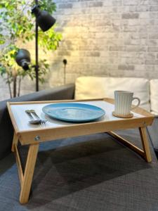 una mesa de café de madera con una placa azul. en Cozy Hyve Soho Suites en Cyberjaya