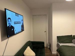 a living room with a flat screen tv on the wall at Charming 6-Bed Apartment in Wembley Area in London