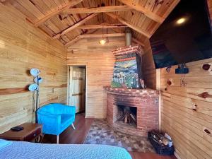 a bedroom with a fireplace in a log cabin at San José del Pacífico Camino al Cielo C3 in San Jose del Pacifico
