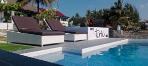 two lounge chairs sitting next to a swimming pool at TOHO NIAS in Telukdalem