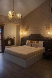 a bedroom with a large bed and a chandelier at Ronda Hotel Boutique by Chat Noir in Cuenca