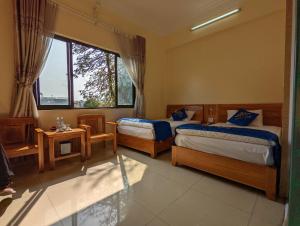 1 dormitorio con 2 camas y ventana en Khách sạn Hoàng Sơn, en Sơn La
