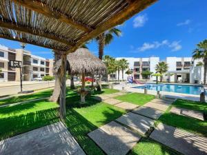 een resort met een zwembad en een rieten parasol bij Prime Location House at Cerritos GREAT PRICE in San Rafael