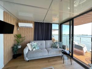 a living room with a couch on a boat at A comfortable house on the water for 4 people in Łazy
