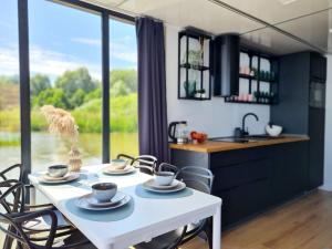 a kitchen and dining room with a table and chairs at Houseboat in azy by Lake Jamno and Sea in Łazy +25 photos