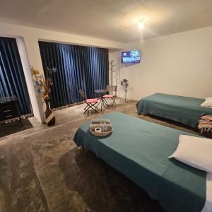 1 dormitorio con 2 camas y TV en la pared en Lima Airport Hostel with FREE AIRPORT PICK UP en Lima