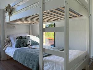 a bedroom with two bunk beds and a window at Comfortable house on the water for 3 people in Łazy