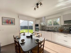a kitchen with a table and chairs in a kitchen at Pretty holiday home in Cotentin in Gouville-sur-Mer