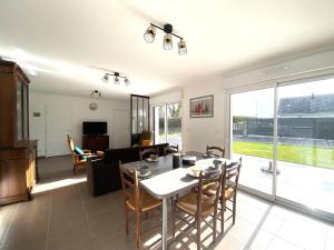 a living room with a table and chairs and a couch at Pretty holiday home in Cotentin in Gouville-sur-Mer