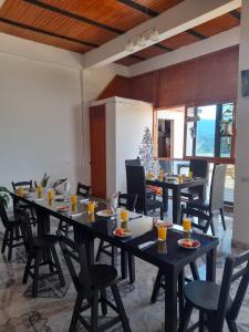 a dining room with tables and chairs with drinks on them at Hostal y Restaurante Lujans in San Agustín