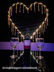 a bottle of wine and two wine glasses with a heart at Hostal y Restaurante Lujans in San Agustín
