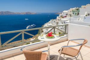 a balcony overlooking the ocean with a view of the beach at The Last Sunbeam - Adults Only in Fira