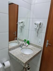 a bathroom with two sinks and a mirror at Bahia Trip Flats in Lençóis