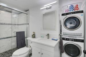 a bathroom with a toilet and a washing machine at Centered Home in West Springfield