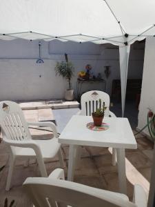 a patio with a table and chairs and an umbrella at Quincho Los Abuelos in Chivilcoy