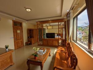 ein Wohnzimmer mit einem Holztisch und einem Sofa in der Unterkunft Khách sạn Hoàng Sơn in Sơn La