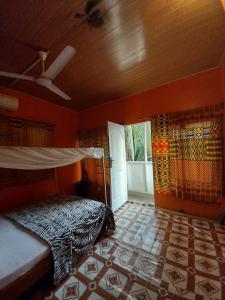 a bedroom with a bed in a room with a window at Orange Beach hostel in Cape Coast