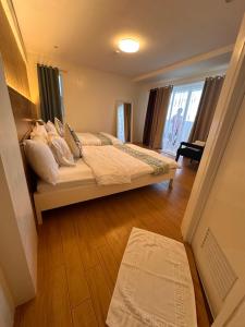 um quarto com uma cama com almofadas e uma janela em CasaDel Beach House em Mabini