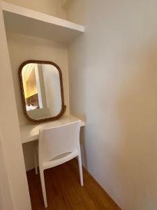 a white dressing table with a mirror and a chair at CasaDel Beach House in Mabini