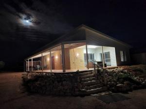 dom ze szklanymi oknami w nocy w obiekcie Poseidon's Oasis - Entire Home - Moonta Bay w mieście Port Moonta