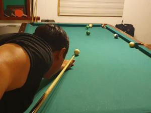 a young boy is playing a game of pool at CABAÑA ENTRE ARRAYANES Y COPIHUES Selva VALDIVIANA in Valdivia