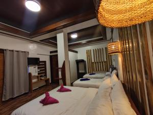 1 dormitorio con 2 camas con almohadas rosas en Cañon Suite en General Luna