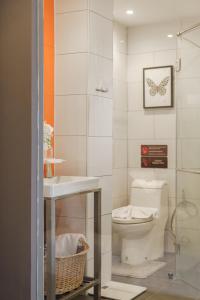 a small bathroom with a toilet and a sink at Eight Hotel Ari in Bangkok