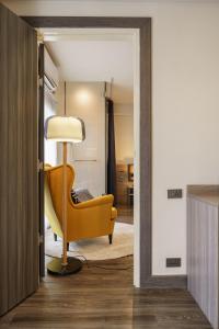 a living room with a yellow chair and a lamp at Eight Hotel Ari in Bangkok
