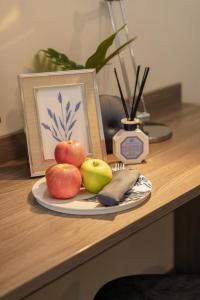 a plate of apples and a picture on a table at Eight Hotel Ari in Bangkok