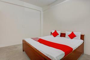 a bedroom with a bed with a red blanket on it at OYO Flagship City Light Hotel in Kānpur