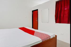 a bedroom with a bed with a red curtain at OYO Flagship City Light Hotel in Kānpur