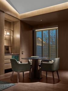 a dining room with a table and chairs and a window at Banyan Tree Suzhou Shishan in Suzhou