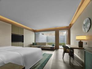 a bedroom with a bed and a living room at Banyan Tree Suzhou Shishan in Suzhou