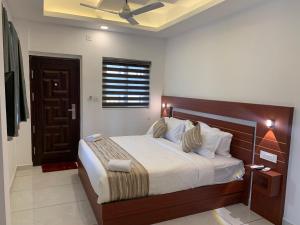 a bedroom with a large bed with a wooden headboard at Misty Avenue Premium Rooms in Anachal