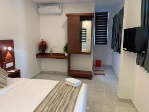a hotel room with a bed and a television at Misty Avenue Premium Rooms in Anachal